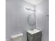 Small bathroom with gray vanity and a round mirror at 3616 N College Ave, Indianapolis, IN 46205