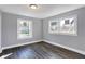 Bedroom with grey walls, wood-look flooring, and two windows at 3616 N College Ave, Indianapolis, IN 46205