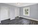 Bright bedroom with grey walls, wood-look flooring, and a window at 3616 N College Ave, Indianapolis, IN 46205