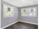 Simple bedroom with grey walls, wood flooring, and two windows at 3616 N College Ave, Indianapolis, IN 46205