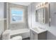 Clean bathroom with marble tile, a vanity, and a bathtub at 3616 N College Ave, Indianapolis, IN 46205