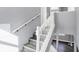 White railing staircase with grey walls and wood flooring at 3616 N College Ave, Indianapolis, IN 46205