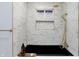 Luxury bathroom with black soaking tub, marble tile, and gold fixtures at 1327 N Gale St, Indianapolis, IN 46201