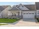 Two-car garage craftsman style home with gray siding and stone accents at 10549 Maidenhair Dr, Indianapolis, IN 46239