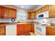 Bright kitchen features wood cabinets, white appliances, and a double sink at 1202 Creek Bend Dr, Greenwood, IN 46143