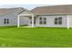 House with gray siding, covered patio, and a grassy backyard at 10612 Maidenhair Dr, Indianapolis, IN 46239