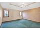 Bright bedroom with teal carpet, neutral walls, and two windows at 6640 Greenridge Dr, Indianapolis, IN 46278