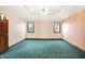 Spacious bedroom with teal carpet and two windows at 6640 Greenridge Dr, Indianapolis, IN 46278