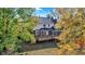 Brick house with a large deck and screened porch nestled amongst fall foliage at 6640 Greenridge Dr, Indianapolis, IN 46278
