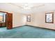 Bright bedroom featuring teal carpet, neutral walls, and two windows at 6640 Greenridge Dr, Indianapolis, IN 46278
