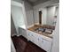 Kitchenette with double sink, white cabinets, and wood-look floors at 709 W Riverside Ave, Muncie, IN 47303