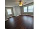 Spacious bedroom with dark wood floors, ceiling fan, and large windows at 709 W Riverside Ave, Muncie, IN 47303
