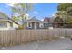 Gray brick house with a white door, partially visible from behind a wooden fence at 1141 W 31St St, Indianapolis, IN 46208