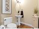 Elegant powder room with pedestal sink, oval mirror, and hardwood floor at 12239 Poplar Bend Blvd, Fishers, IN 46037