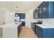Modern kitchen boasts navy cabinets, stainless steel appliances, and a large island at 7144 Rose Hill Ave, Brownsburg, IN 46112