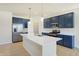 Modern kitchen with navy cabinets, stainless steel appliances & large island at 7144 Rose Hill Ave, Brownsburg, IN 46112