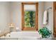 Relaxing bathroom with soaking tub, wood framed window, and neutral tile at 6902 Creekridge Trl, Indianapolis, IN 46256