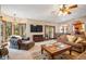 Bright living room boasts expansive windows, comfortable seating, and a large TV at 6902 Creekridge Trl, Indianapolis, IN 46256