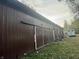 Long brown barn with sliding doors and a horse trailer at 8353 N Sr 109, Wilkinson, IN 46186