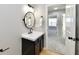 Modern bathroom with a black vanity and a round mirror at 6919 Wilmot Ln, Avon, IN 46123