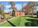 Landscaped backyard with brick building, stone pathway, and lush lawn at 2505 Riverside Dr, Columbus, IN 47201