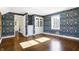 Bright bedroom with hardwood floors, floral wallpaper and access to hallway at 2505 Riverside Dr, Columbus, IN 47201