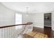 Upper hallway with patterned wallpaper, hardwood floors, and curved railing at 2505 Riverside Dr, Columbus, IN 47201