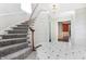 Curved staircase with gray carpet runner and marble flooring at 2505 Riverside Dr, Columbus, IN 47201