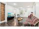 Living room with exposed brick wall, hardwood floors, and TV at 2028 Hoyt Ave, Indianapolis, IN 46203