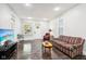 Living room with plaid couch, dark hardwood floors, and TV at 2028 Hoyt Ave, Indianapolis, IN 46203
