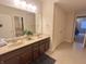 Double vanity bathroom with a large mirror and dark brown cabinets at 7610 Monte Carlo Way, Indianapolis, IN 46278