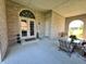 Spacious covered patio with brick walls, seating area, and access to backyard at 7610 Monte Carlo Way, Indianapolis, IN 46278