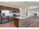 Open concept kitchen with island, stainless steel appliances, and hardwood floors at 5856 Fair Oak Cir, Brownsburg, IN 46112