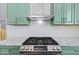 Modern kitchen features gas range and green cabinets at 631 Cottage Ave, Indianapolis, IN 46203