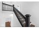 Dark wood staircase with black railing at 631 Cottage Ave, Indianapolis, IN 46203