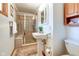 Updated bathroom with a pedestal sink, shower, and built-in shelving at 104 Mohawk Ln, West Lafayette, IN 47906