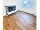 Living room featuring hardwood floors, a fireplace, and large window at 2442 N Franklin Rd, Indianapolis, IN 46219
