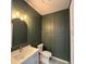 Modern powder room with dark green walls and gold accents at 2413 Griton Ct, Shelbyville, IN 46176