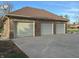 Three-car brick garage with light-grey doors at 2413 Griton Ct, Shelbyville, IN 46176