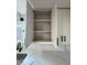 Open white kitchen cabinets with three shelves offer ample storage at 2413 Griton Ct, Shelbyville, IN 46176