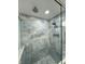 Walk-in shower with double shower heads and blue marble-look tile at 2413 Griton Ct, Shelbyville, IN 46176