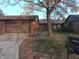 Brick ranch home with attached garage and mature trees in the front yard at 5215 Fawn Hill Ter, Indianapolis, IN 46226