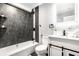Modern basement bathroom with dark tile, white vanity, and a shower/tub combo at 1621 Draper St, Indianapolis, IN 46203