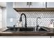 Modern farmhouse kitchen sink with black faucet and herringbone tile backsplash at 1621 Draper St, Indianapolis, IN 46203
