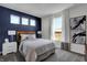 Bedroom with blue accent wall, large window, and striped bedding at 3628 Planck Cir, Danville, IN 46122