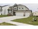 Two-story house with gray and brown siding, three-car garage, and landscaping at 9442 Larson Dr, Pendleton, IN 46064