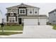 Two-story home with gray siding, brick accents, and a three-car garage at 9442 Larson Dr, Pendleton, IN 46064
