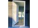 Open white door revealing a light teal living room with hardwood floors at 1601 Draper St, Indianapolis, IN 46203