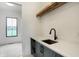 Laundry room with gray cabinets, black faucet, and wood shelving at 5035 Abington Way, Zionsville, IN 46077