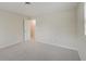 Simple bedroom with neutral walls, carpet, and an open door to another room at 4902 N Capitol Ave, Indianapolis, IN 46208